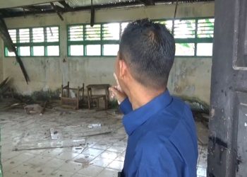 Guru SMP Negeri 4 Muaro Jambi tengah menunjukkan salah satu ruang kelas yang mengalami kerusakan parah. Kelas tersebut tak lagi difungsikan karna dapat membahayakan siswa dan guru, lantaran material atap bangunan yang rapuh. (foto:ist)