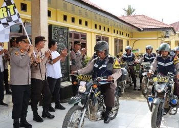 Kapolres Tanjab Timur AKBP Andi Muh Ichsan Usman, mengangkat bendera start tanda dibukanya program Bhabinkamtibmas Bersedekah. (Dok istimewa)