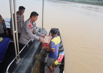 Kapolda Jambi menyerahkan bantuan kepada nelayan yang sedang mencari ikan, yang ia temui di pinggiran Sungai Batanghari Selasa (3/1/2023).(dok Humas Polda Jambi)