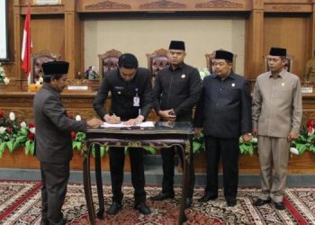 Pj Bupati Muarojambi, Bachyuni Deliansyah, didampigi Ketua DPRD Muarojambi menandatangani Ranperda Tentang Pengolahan Keuangan Daerah Muarojambi. (Foto BITNews.id/Rz)