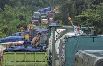 Sopir berdiri di atas truk saat sejumlah kendaraan yang didominasi truk bermuatan batu bara mengantre di Jalan Lintas Sarolangun-Muara Tembesi, Batanghari, Jambi, Rabu (1/3/2023). (ANTARA FOTO/WAHDI SEPTIAWAN)