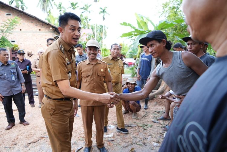 Pj Bupati Muaro Jambi saat berada di sungai gelam untuk meninjau rumah warga yang rusak tertimpa pohon tuumbang (dok. Kominfo)